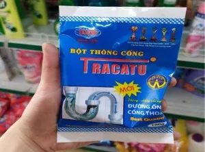 Bàn tay cầm túi bột thông cống Tracatu.