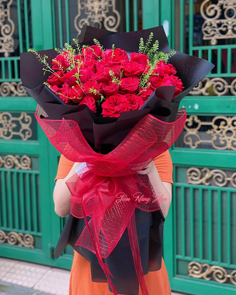 Chậu hoa lan Cửu Bảo Tiên màu đỏ rực rỡ đang nở rộ trong vườn
